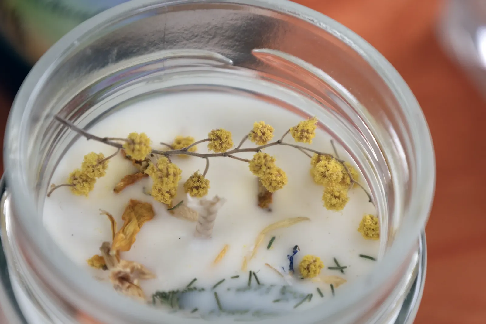 Bougie artisanale décorée de mimosa et de fleurs séchées