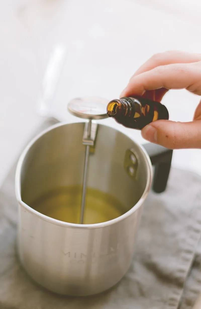 Ajout d'huile parfumée dans la cire fondue